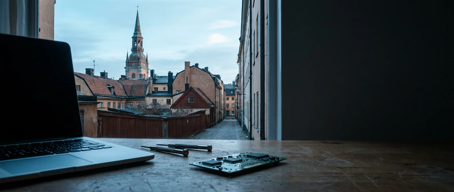 Maria Magdalena kyrkans torn över Södermalm i Stockholm med MacBook på TeknikFix verkstadsbänk i förgrunden